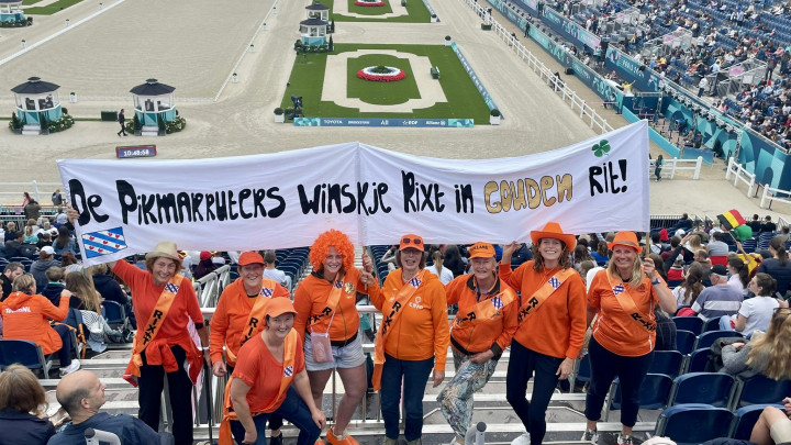 Een delegatie van De Pikmarruters op de tribune in Parijs, met het spandoek.