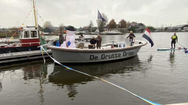 Met een grote schaar knipt de wethouder het lint door.