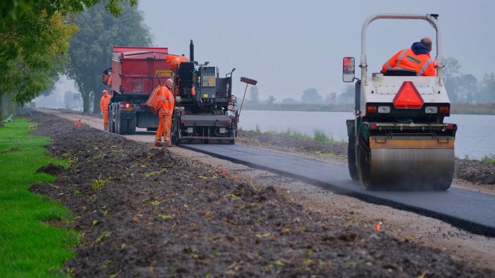 Medewerkers van Oosterhof Holman zijn druk bezig met het asfalteren van het pad. (Foto: Jannes Postma)