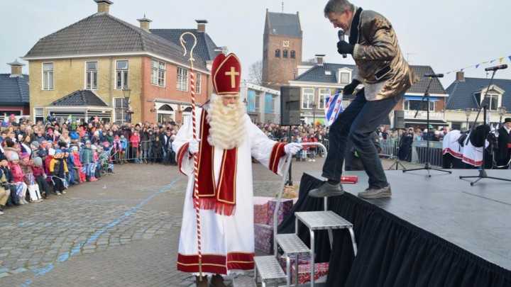 Terwijl honderden kinderen in spanning wachten, betreedt Sint Piter het podium op het plein.