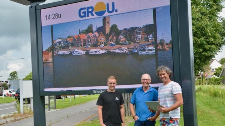 Dominicus Bijlsma (midden) van Grou Aktief en Patrick Koene van De Rode Loper zijn blij met het scherm. Links de monteur van Ledyears.